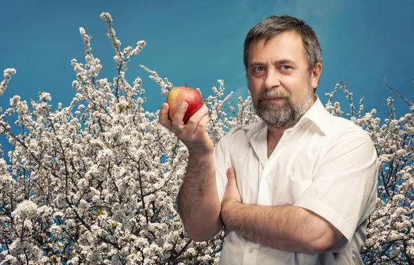Homem de meia-idade segurando uma maçã vermelha — Fotografia de Stock