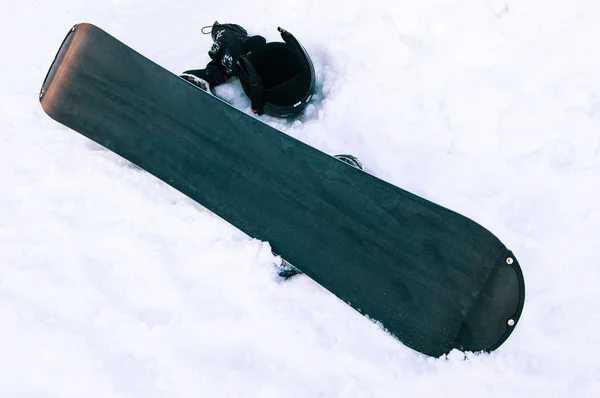 Papan untuk snowboarding dan helm di salju — Stok Foto