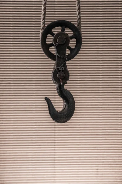 Big metal hook hanging on rope