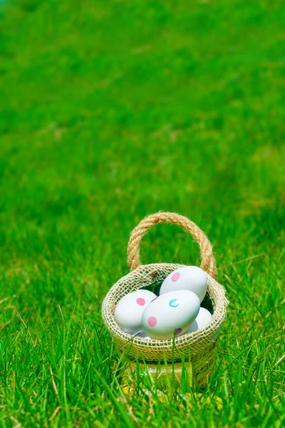 Easter eggs in basket on green grass — Stock Photo, Image