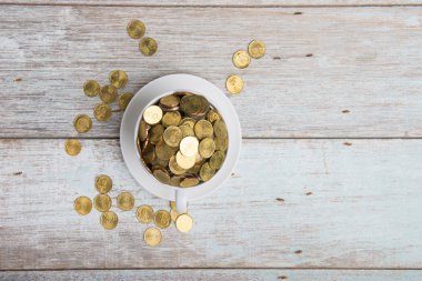 Altın sikke ile kahve fincanı