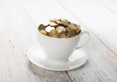 Altın sikke ile kahve fincanı