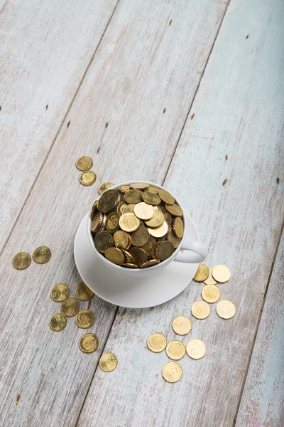 Кавова чашка з золотими монетами — стокове фото