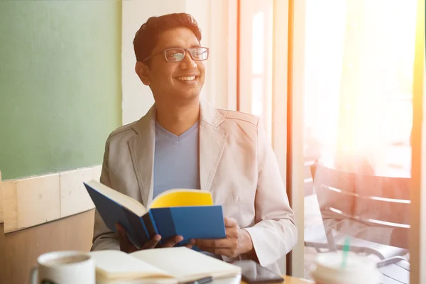 Libro di lettura maschile casuale indiano e godendo di caffè — Foto Stock