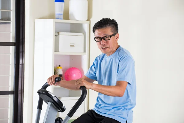 Asian mężczyzna na rower treningowy — Zdjęcie stockowe