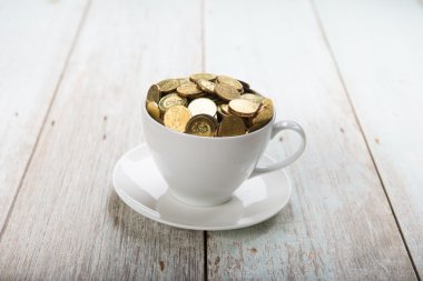 Altın sikke ile kahve fincanı