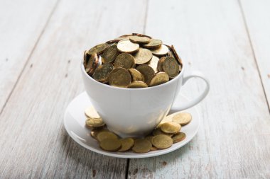 Altın sikke ile kahve fincanı