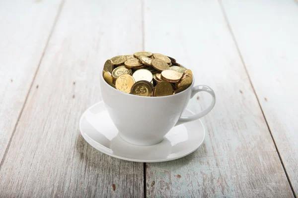 Кавова чашка з золотими монетами — стокове фото