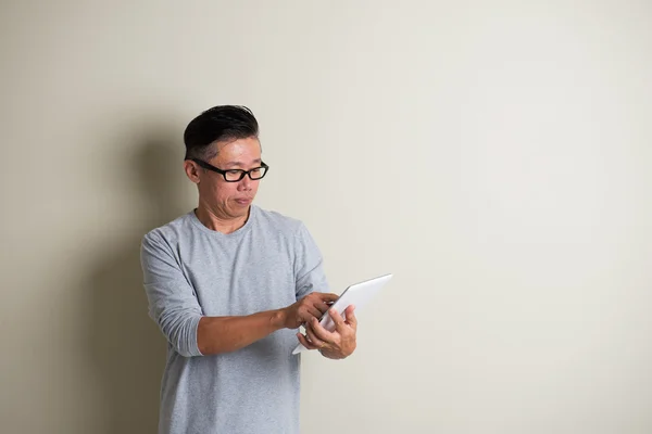 Gereifter asiatischer Mann mit Tablette — Stockfoto