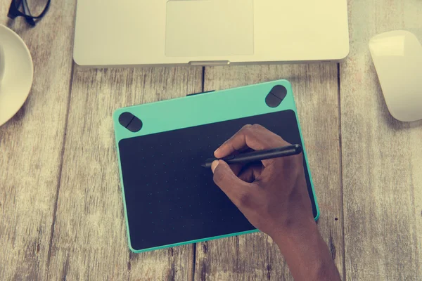 Дизайнер с ноутбуком и графическим планшетом — стоковое фото