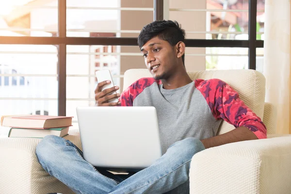 Adolescente indio chico con ordenador portátil y teléfono — Foto de Stock