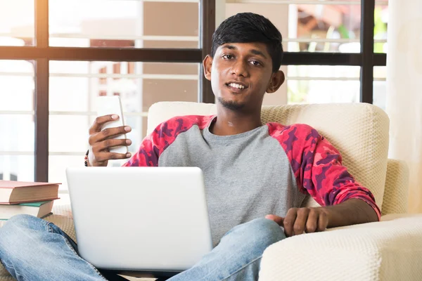 Indisk pojke med laptop och telefon — Stockfoto