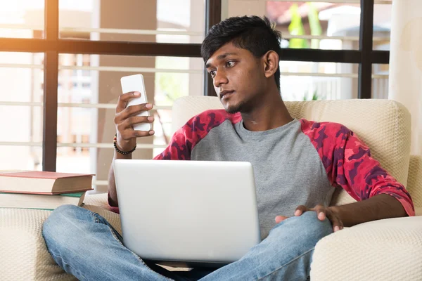 Indian boy using laptop and phone — Stock Photo, Image