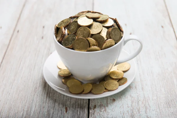 Чашка кави з золотими монетами — стокове фото