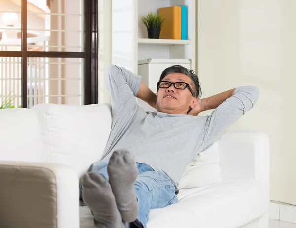 Azjatycki człowiek relaksujący na kanapie — Zdjęcie stockowe