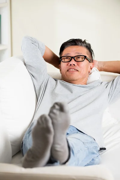 Aziatisch mens ontspannen op de sofa — Stockfoto