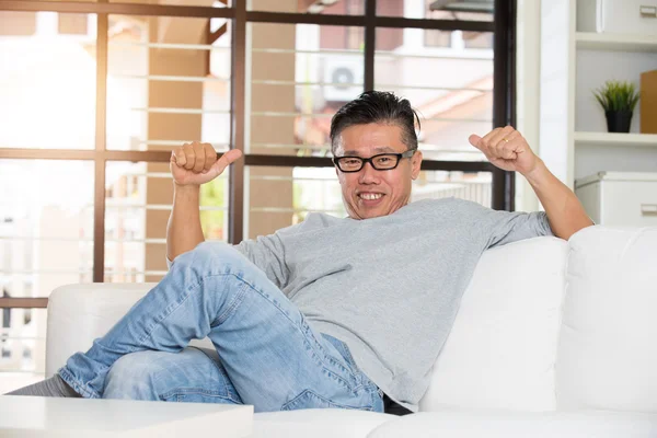 Asiatischer Mann sitzt auf Sofa — Stockfoto