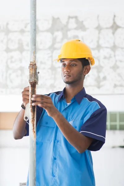 Indian male plumber on site using hammer — Stock Photo, Image