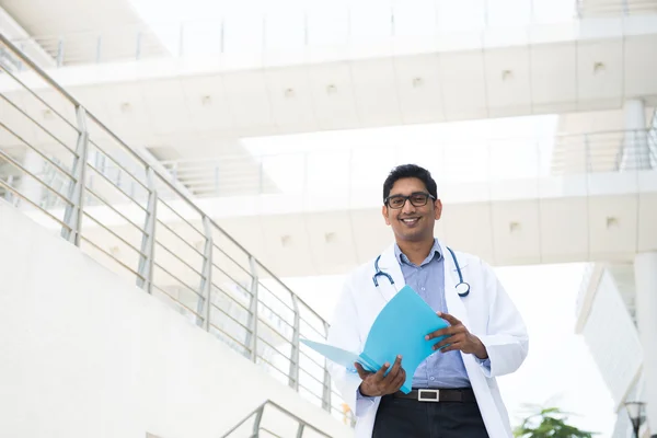 Indian male doctor reading report — Stock Photo, Image