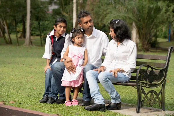 Индийская семья сидит на скамейке — стоковое фото