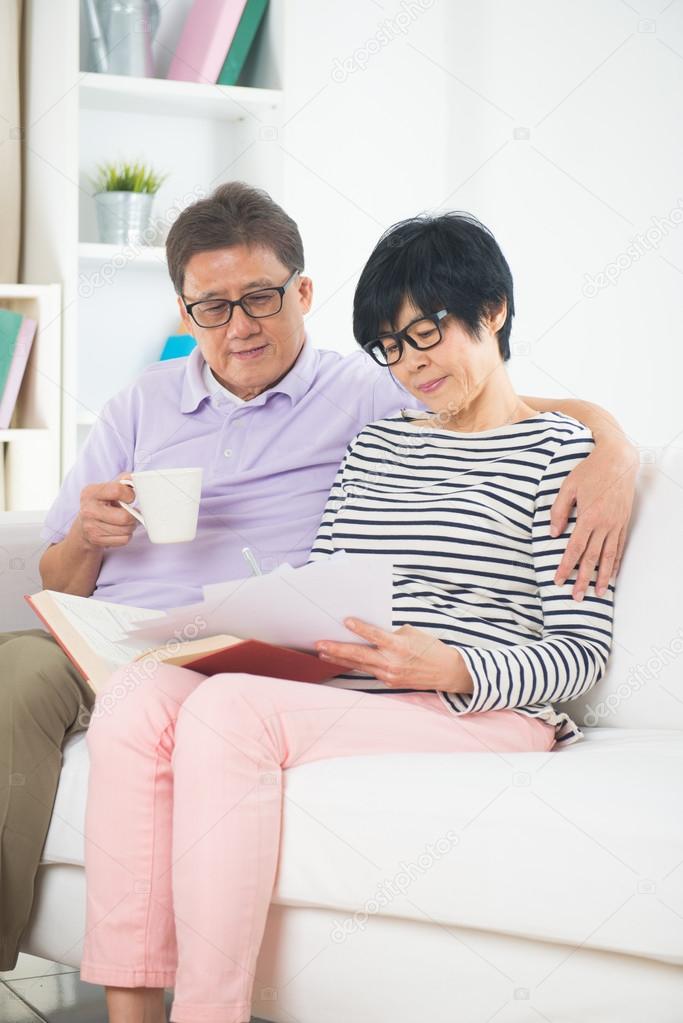 Asian senior couple reading book