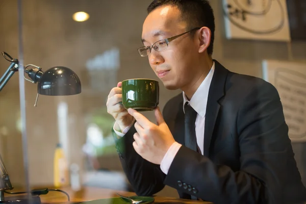 Asian business man having coffee — Stock Photo, Image