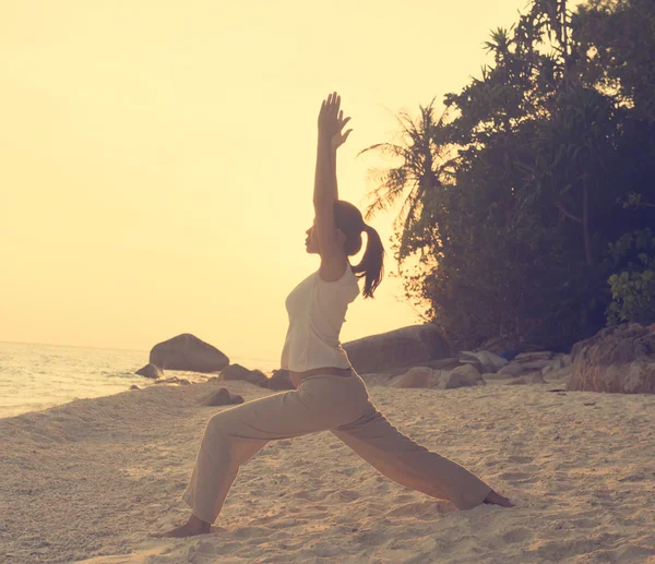 Kadın plajda yoga yapıyor. — Stok fotoğraf