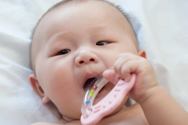 Aziatische baby speelgoed bijten — Stockfoto