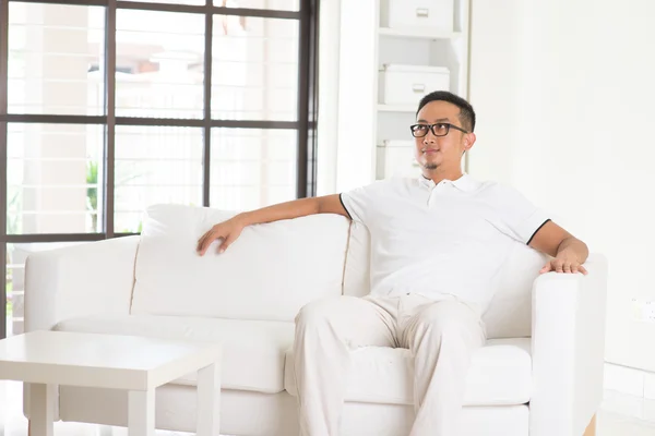 Asiático hombre sentado en sofá — Foto de Stock