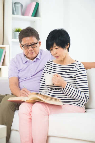 Senior asian couple reading a book — Stock Photo, Image