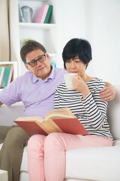 Senior asiático pareja leyendo un libro — Foto de Stock