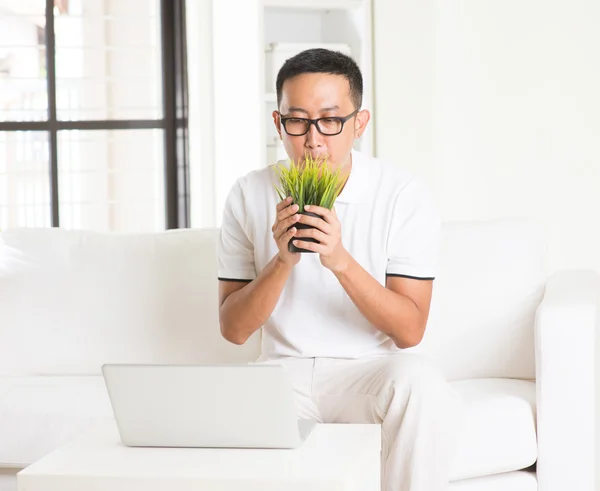 Asian man sniffing grass — Stock Photo, Image