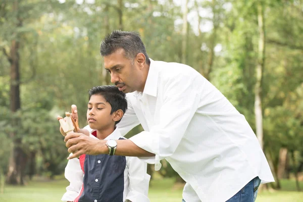 インド人の父親と息子のスリング ショットを演奏 — ストック写真