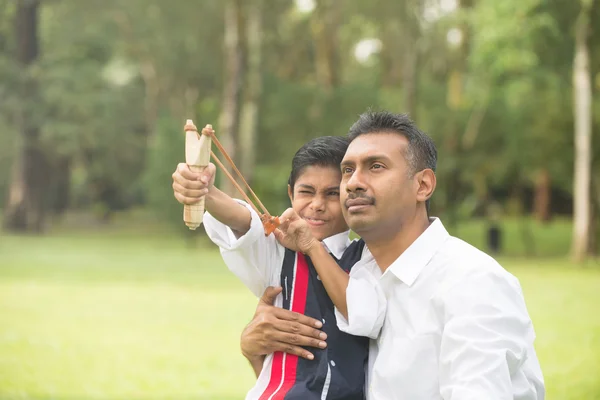 Indian father and son playing slingshot — Stock Photo, Image