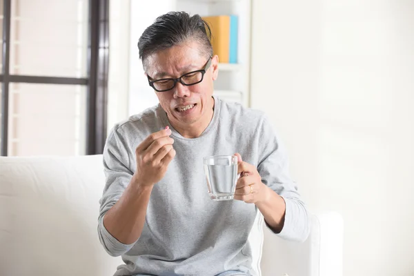 Asiatiska senior mannen ta piller — Stockfoto