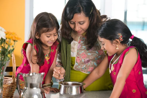 indian mother cooking with daughters
