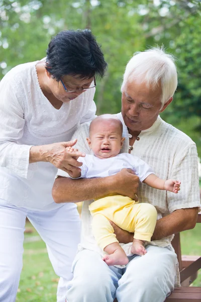 Бабушка с дедушкой играют с внуком — стоковое фото