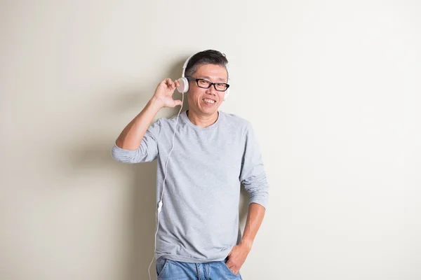 Ásia homem ouvindo música — Fotografia de Stock