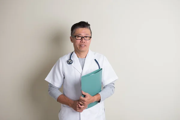 Азиатский старший врач с папкой — стоковое фото