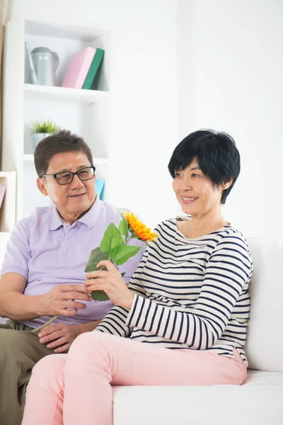 Aziatische senior paar geven zonnebloem — Stockfoto