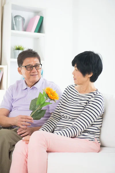 Aziatische senior paar geven zonnebloem — Stockfoto