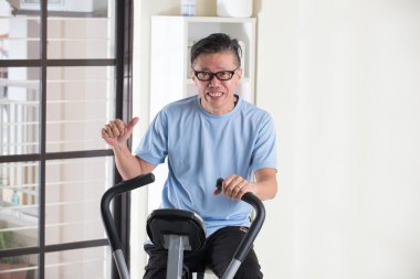 Egzersiz bisikleti üzerinde Asya kıdemli erkek