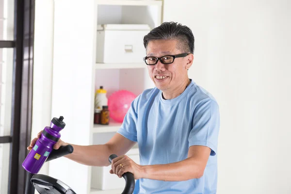 Azjatycki starszy mężczyzna na rower treningowy — Zdjęcie stockowe
