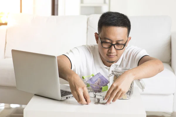 Asian male online with money — Stock Photo, Image