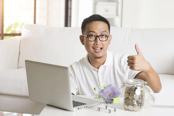 Asian male online with money — Stock Photo, Image