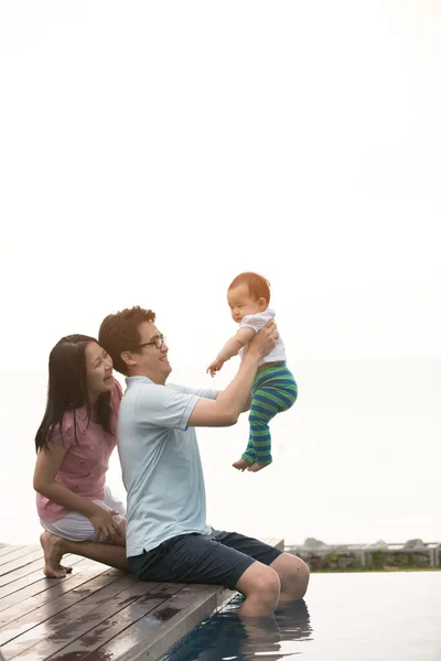 Asiatiska familj vid poolen — Stockfoto