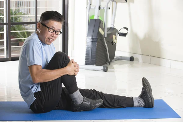 Asiático hombre haciendo la pierna estiramiento —  Fotos de Stock