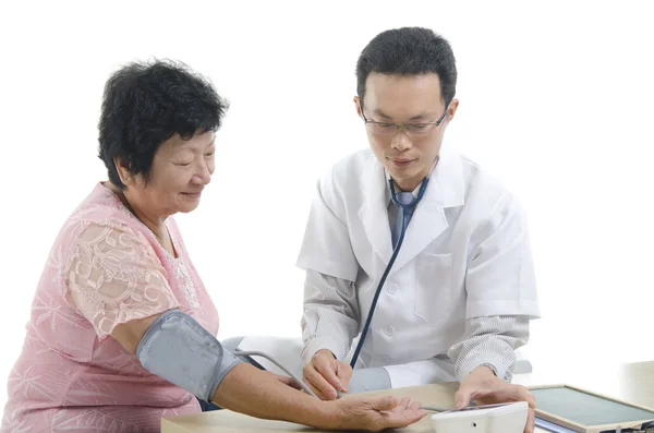 Doctor checking up a senior patient — Stockfoto