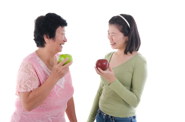 Mujer mayor con hija teniendo manzanas — Foto de Stock