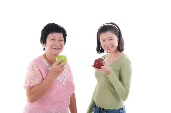 Senior woman with daughter having apples — Stok fotoğraf